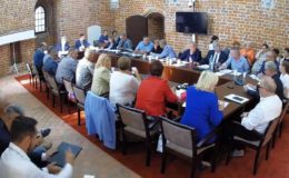 widać radnych i osoby uczestniczące w sesji rady miasta, sesja odbywa się w sali zamkowej, uczestnicy siedzą za stołem