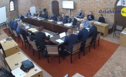 widać radnych i osoby uczestniczące w sesji rady miasta, sesja odbywa się w sali zamkowej, uczestnicy siedzą za stołem