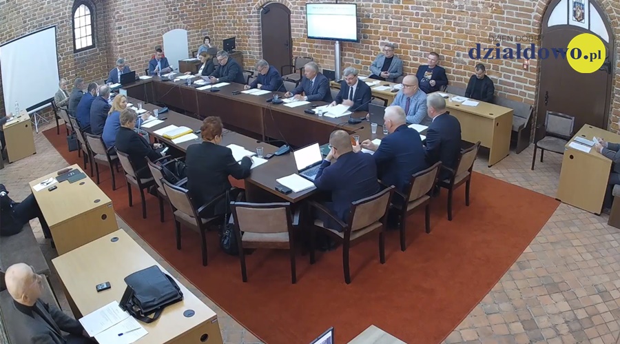 widać radnych i osoby uczestniczące w sesji rady miasta, sesja odbywa się w sali zamkowej, uczestnicy siedzą za stołem