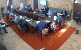 widać radnych i osoby uczestniczące w sesji rady miasta, sesja odbywa się w sali zamkowej, uczestnicy siedzą za stołem