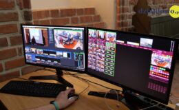dwa monitory komputerowe stoją na biurku, widać na nich relację sesji rady miasta online