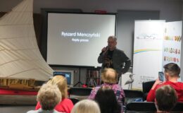 Ryszard Menczyński opowiada przez mikrofon o swoich rajdach w bibliotece