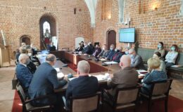 radni i osoby uczestniczące w sesji rady miasta, sesja odbywa się w sali zamkowej uczestnicy siedzą za stołem