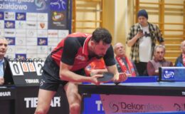 Patryk Chojnowski, tenisista Dekorglassu Działdowo stoi przy stole do gry w tenisa, serwuję