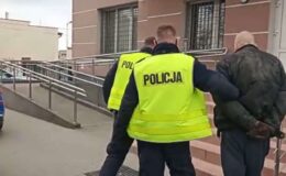 dwóch policjantów prowadzących mężczyznę po schodach komendy policji
