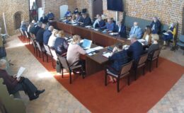 Na zdjęciu widać radnych i osoby uczestniczące w sesji rady miasta, sesja odbywa się w sali zamkowej uczestnicy siedzą za stołem