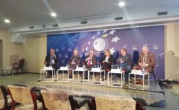 za stołem siedzą prelegenci panelu dyskusyjnego, kobiety i mężczyźni