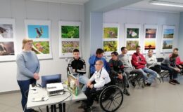 Fotografia przedstawia uczestników zajęć, którzy słuchają wykładu, prezentowanego przez panią bibliotekarkę