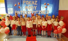 stoją dzieci ubrane w barwy biało-czerwone podczas obchodów świąt majowych w przedszkolu