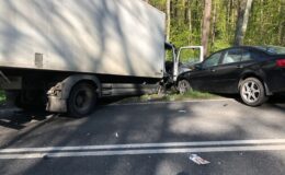 dwa samochody, dostawczy i osobowy stoją w rowie przy drodze
