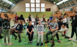 grupa uczniów uczestniczy w zabawach z okazji Dnia Dziecka, zabawa odbywa się w sali gimnastycznej szkoły