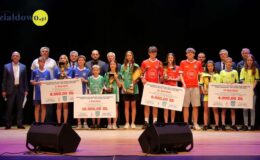 na scenie MDK, stoją uczniowie i dorośli, niektóre osoby trzymają puchary i symboliczne czeki