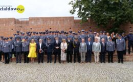 policjantki, policjanci, zaproszeni goście na dziedzińcu działdowskiego zamku pozują do pamiątkowej fotografii