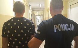 policjant prowadzi osobę zatrzymaną