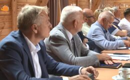 za stołem siedzi grupa osób