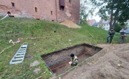 widzimy wykop archeologiczny, przy działdowskim zamku, oraz trzy osoby, podczas prac