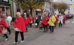 grupa osób idzie ulicą miasta
