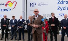 stoi grupa osób przed mikrofonami podczas konferencji prasowej