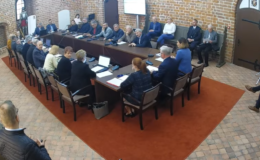 widać radnych i osoby uczestniczące w sesji rady miasta, sesja odbywa się w sali zamkowej, uczestnicy siedzą za stołem