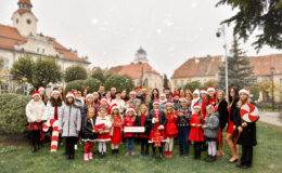 stoi grupa osób (dzieci, dorośli), w tle działdowski ratusz