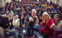 pamiątkowa fotografia Sashy Sidorenko, m.in. wraz uczniami i Anną Ostrowską (wszyscy kucają) na scenie Miejskiego Domu Kultury w Działdowie, w tle na widowni młodzież