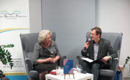 kobieta (Alicja Poturnicka) i mężczyzna (Piotr Kozikowski) siedzą i prowadzą rozmowę podczas wieczorku poetyckiego w sali Miejskiej Biblioteki Publicznej w Działdowie