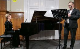 kobieta i mężczyzna grają na instrumentach. Kobieta gra na fortepianie, a mężczyzna na klarnecie
