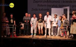 grupa osób, kobiety, mężczyźni stoją na scenie Miejskiego Domu Kultury