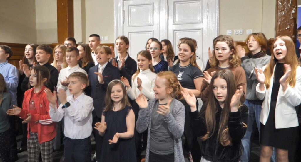 stoi w grupa dzieci i młodzieży, śpiewa