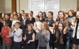 stoi w grupa dzieci i młodzieży, śpiewa