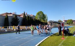 grupa osób biegnie po bieżni stadionu