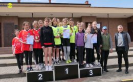na podium stoją trzy najlepsze drużyny dziewcząt, obok stoją trener Jacek Cytlał i nauczyciel Leszek Sosnówka