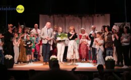na scenie Miejskiego Domu Kultury stoi grupa dorosłych i dzieci
