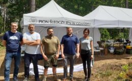 w lesie stoją 4 mężczyźni i jedna kobieta
