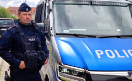 policjant stoi przy radiowozie - mł.asp. Piotr Oryl