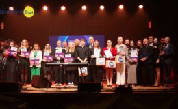 na scenie stoi grupa osób, młodzież, dorośli, wszyscy pozują do pamiątkowej fotografii