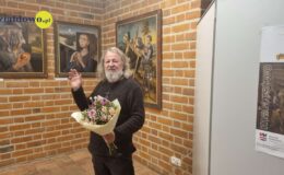 artysta malarz Dariusz Miliński, w otoczeniu swoich obrazów, podczas wernisażu wystawy w Muzeum Pogranicza