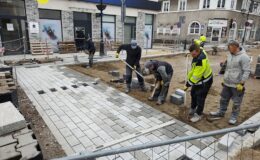 widać moment układania przez pracowników pierwszych metrów kostki granitowej na ul. Jagiełły