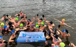 pamiątkowa fotografia Morsów Działdowo podczas I Powiatowego Festiwalu Morsowania w Lidzbarku, na zdjęciu widać osoby kapiące się w jeziorze