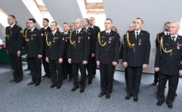 stoi grupa strażaków w pomieszczeniu, pierwszy z prawej bryg. Piotr Bojanowski