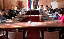 młodzież i osoby dorosłe siedzące za stołem, młodzież rozwiązuje test