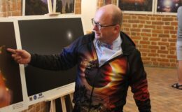 Robert Szaj i plansza z ekspozycji "Kopernik tego nie widział"
