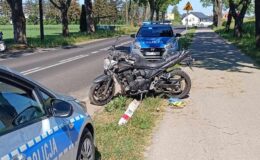 motocykl na drodze i zaparkowany radiowóz
