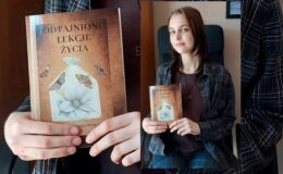 poetka Natalia Kłosowska trzyma swoją książkę "Odtajnione lekcje życia"