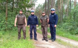 stoją policjanci i leśnicy w lesie / fot. policja