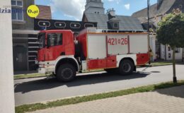 wóz strażacki jedzie drogą w mieście