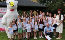 grupa dzieci i dorosłych pozuje do pamiątkowej fotografii