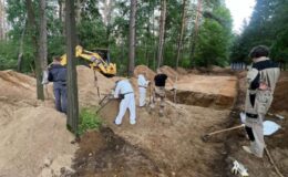badania w lesie w Białutach, widać osoby przy pracy i masowy grób
