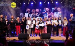 na scenie stoją młodzi wokaliści oraz osoby dorosłe na scenie festiwalowej w hali sportowej SP nr 2 w Działdowie