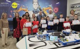 stoją dzieci i dorośli pozując do pamiątkowej fotografii z II Konkursu Super Lego Day w Szkole Podstawowej nr 4 w Działdowie